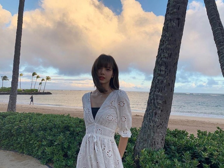 Potret Lisa saat berpose dengan latar pemandangan pantai saat sedang senja.