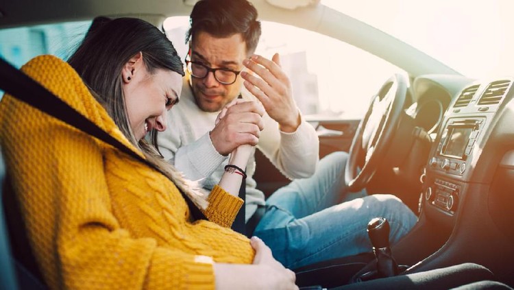 Ilustrasi ibu hamil jelang melahirkan Pregnant woman starting to feel pain and contractions while her worried husband driving a car. She is ready to give birth in a car.