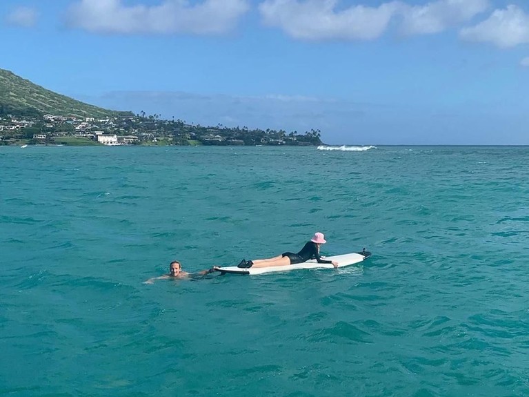 Rose bermain papan selancar di tengah indahnya laut Hawai.