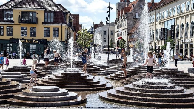 People cool down in the fountains as temperatures reached 30 degrees Celsius, at Toldbod Plads in Aalborg, Denmark, Wednesday July 24, 2019. (Henning Bagger/Ritzau Scanpix via AP)