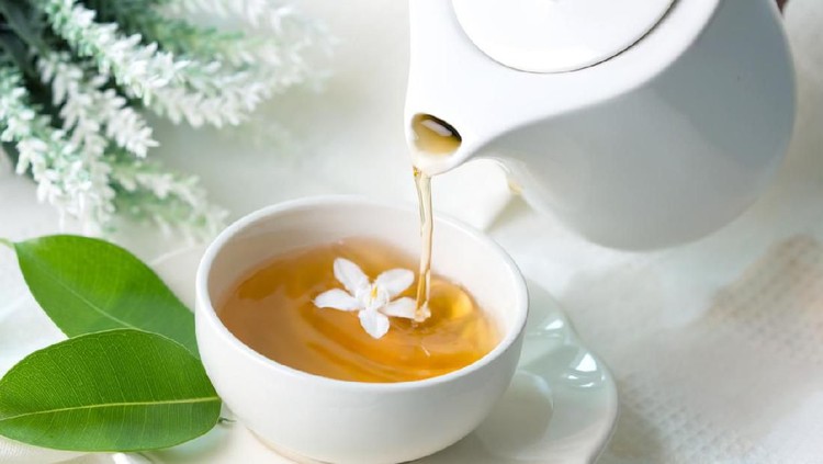 Close up pouring hot jasmine tea in a white tea cup ,  Tea ceremony time concept