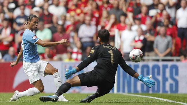 Manchester City's Leroy Sane, left, shoots at goal as Liverpool's goalkeeper Alisson Becker goes to block during the Community Shield soccer match between Manchester City and Liverpool at Wembley Stadium in London, Sunday, Aug. 4, 2019. (AP Photo/Frank Augstein)