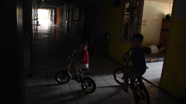 Dua anak bermain di Rusun Bendungan Hilir saat terjadi pemadaman listrik bergilir di Jakarta, Senin (5/8/2019). Gangguan listrik yang terjadi sejak Minggu (4/8) belum sepenuhnya pulih hingga Senin (5/8) dan PT PLN (Persero) menyatakan pemadaman bergilir masih akan berlangsung karena masih terganggunya sistem pendistribusian listrik. ANTARA FOTO/Indrianto Eko Suwarso/ama.