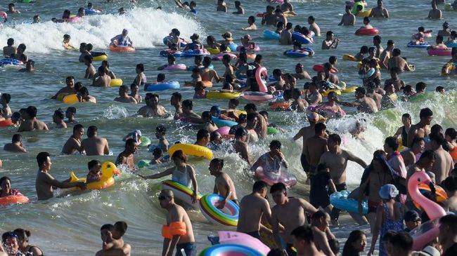 Pantai-pantai di China terlihat berwarna-warni dengan ban renang yang dibawa turis.