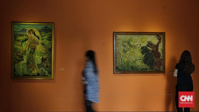Pengunjung menyaksikan karya lukisan berjudul "Dewi Sri" dan " Togog Penghalau Burung" dalam Pameran Seni Rupa Koleksi Nasional “Lini Transisi" yang digelar di Galeri Nasional di Jakarta. Kamis, 8 Agustus 2019. sebanyak 50 karya yang terdiri atas lukisan, patung, instalasi, dan video ditampilkan dalam pameran tersebut. Karya-karya tersebut berasal dari 40 seniman Indonesia yang diciptakan sejak tahun 1950–an hingga tahun 1980–an. CNN Indonesia/Adhi Wicaksono