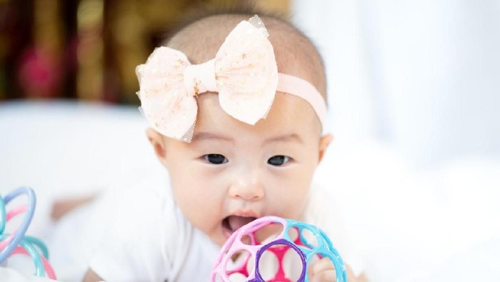 Asian baby happy in the room.Asian baby girl lying down on bed .