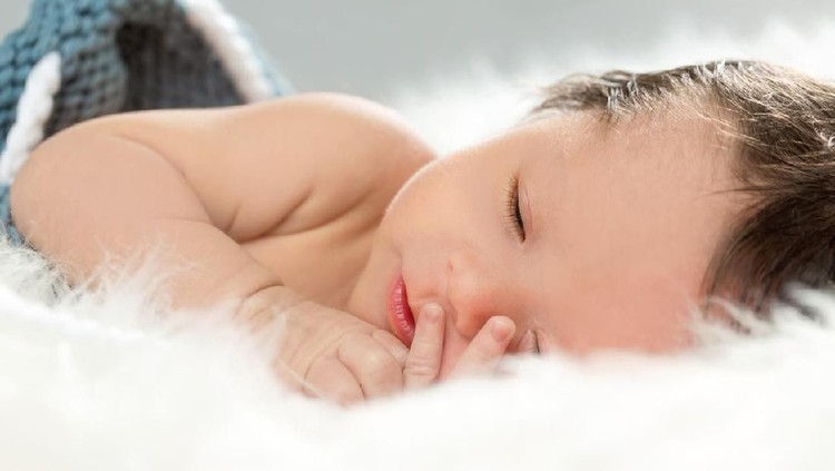 Little baby boy sleeping on a fluffy blanket