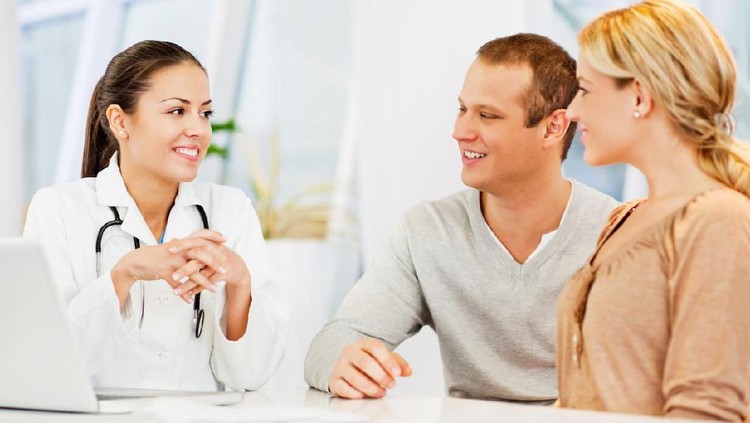 183493980 Happy Doctor Discussing With Couple In Clinic