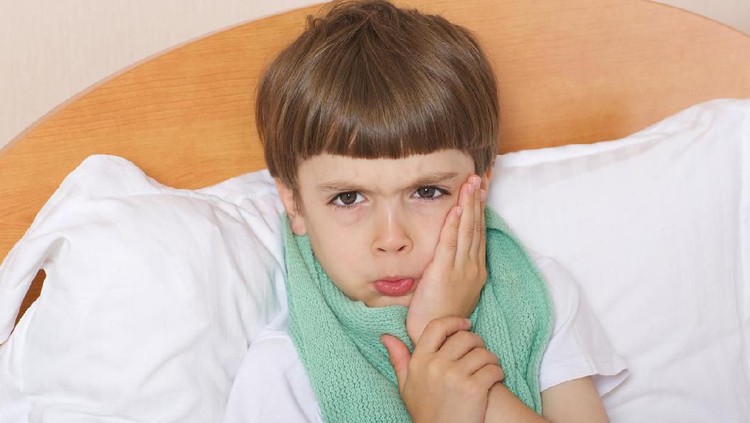 One year old baby crying in bed with a teddy bear
