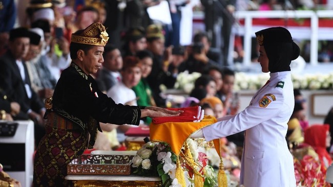 Presiden Joko Widodo menyerahkan duplikat bendera pusaka kepada Paskibraka Tarrisa Maharani Dewi saat  Upacara Peringatan Detik-Detik Proklamasi Kemerdekaan Indonesia ke-74 Tahun 2019 di Istana Merdeka, Jakarta, Sabtu (17/8/2019). ANTARA FOTO/Wahyu Putro A/foc.
