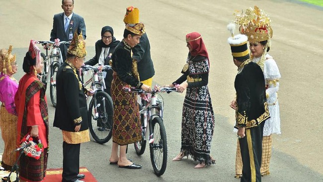 Presiden Jokowi memberikan sepeda kepada tamu undangan yang mengenakan baju adat terbaik dalam upacara HUT RI di Istana Negara, Jakarta