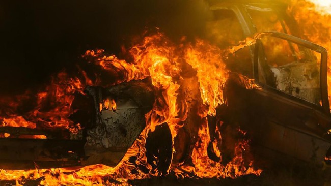Car covered in flames with doors ripped open