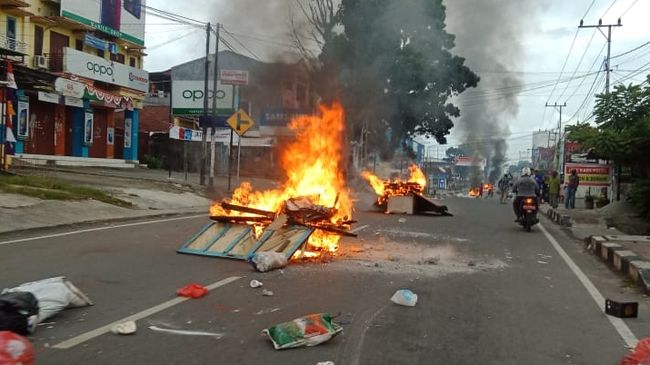 Mahasiswa dan massa menggelar aksi blokade jalan di Manokwari, Papua Barat, merespons kejadian di Surabaya. Terjadi pembakaran. Warga tak berani keluar rumah.