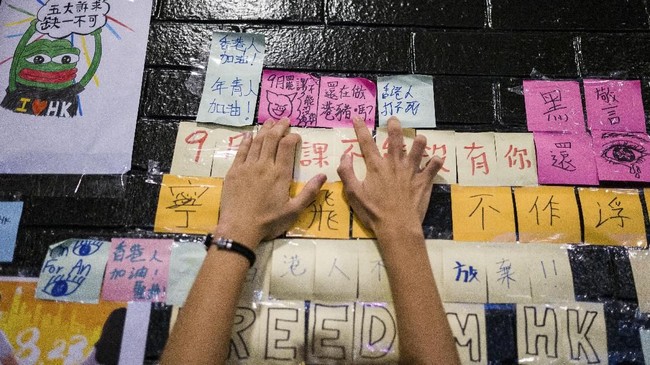 Masyarakat Hong Kong saling menggenggam tangan satu sama lain sebagai bagian dari aksi protes yang kini sudah berlangsung hampir tiga bulan lamanya.