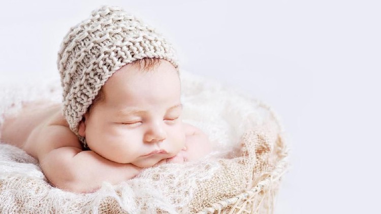 Sweet newborn baby sleeps.  Newborn boy folded handles  in a basket. Copy space