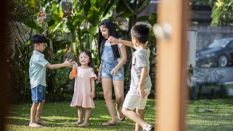 Family playing outdoors with bubbles
