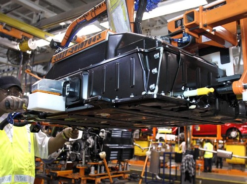 Seorang pekerja mendemonstrasikan instalasi baterai untuk Ford Focus di pabrik perakitan Ford Motor Co. di Michigan, Amerika Serikat, pada 14 Desember 2011.
