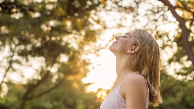 Asian women drinking coffee and wake up in her bed fully rested and open the curtains in the morning to get fresh air on sunshine