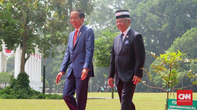 Joko Widodo mengajak tamu undangan mengangkat gelas untuk kesehatan Raja Malaysia yang berkunjung ke Istana Bogor bersama istrinya pada Selasa (27/8).