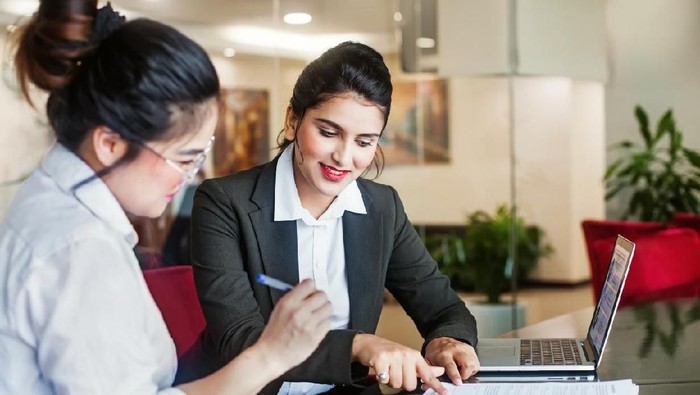 Indian female agent helping client sign the application document