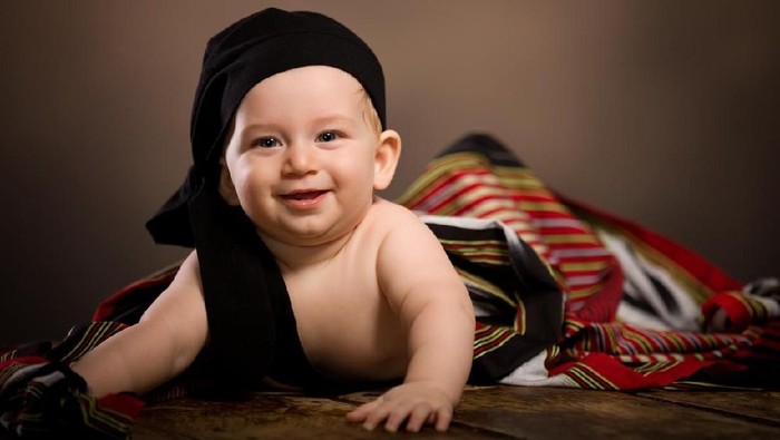 Happy baby on wood floor.