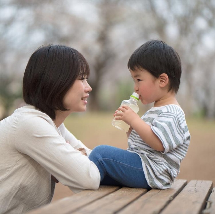 Mother and child sitting on bench and talking