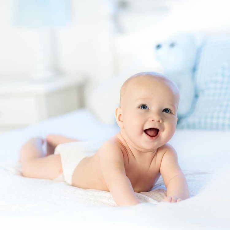 Ilustrasi bayi laki-laki Baby boy wearing diaper in white sunny bedroom. Newborn child relaxing in bed. Nursery for children. Textile and bedding for kids. Family morning at home. New born kid during tummy time with toy bear.