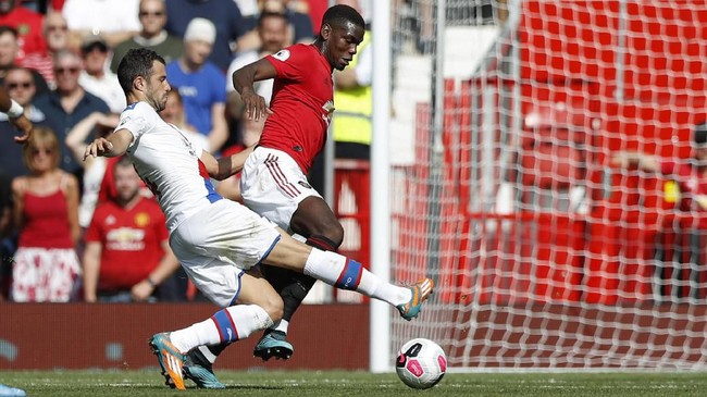 Crystal Palace's Luka Milivojevic, left, tackles Manchester United's Paul Pogba during their English Premier League soccer match between Manchester United and Crystal Palace at Old Trafford in Manchester, England Saturday, Aug, 24, 2019. (AP Photo/Alastair Grant)