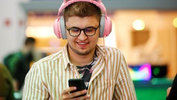 A man with headphones looks at his mobile phine at the IFA consumer electronics fair in Berlin, Germany, September 4, 2019. REUTERS/Hannibal Hanschke