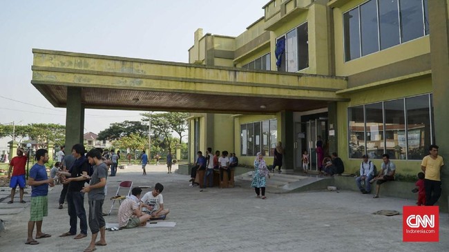 Puluhan orang tua murid bersama anggota PPSU Kalideres kerja bakti membersihkan sampah-sampah di Gedung eks Kodim yang menjadi tempat penampungan pencari suaka.