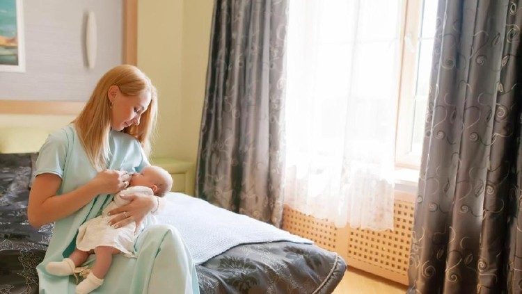 Breastfeeding, beautiful young mom and little baby at home. Motherhood.