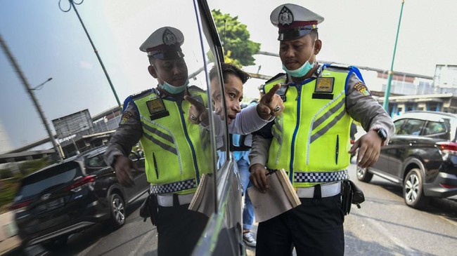 Petugas kepolisian menghentikan mobil berplat nomor genap yang memasuki Jalan Salemba Raya, di Matraman, Jakarta, Senin (9/9/2019). Petugas kepolisian mulai memberlakukan penindakan berupa tilang terhadap pengendara mobil yang melanggar di kawasan perluasan sistem ganjil-genap. ANTARA FOTO/Galih Pradipta