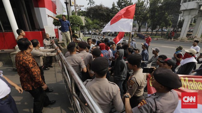 Massa memaksa masuk ke lobby Gedung KPK. Karena tak diperbolehkan, massa melempari gedung KPK dengan batu, botol hingga bambu.