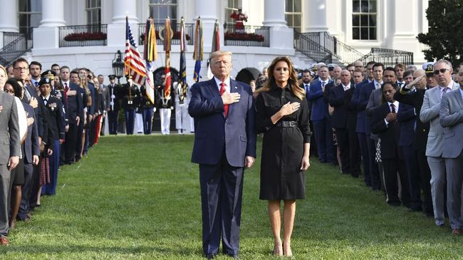 US President Donald Trump and First Lady Melania Trump observe a moment of silence on the South Lawn of the White House to mark the 18th anniversary of the 9/11 attacks, on September 11, 2019, in Washington, DC. (Photo by Nicholas Kamm / AFP)