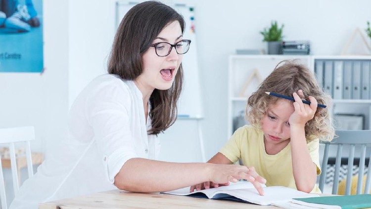 Speech therapist teaching a language an autistic child in an office