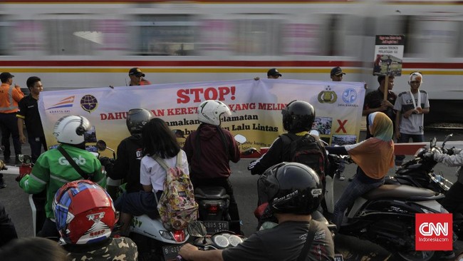 Polisi melakukan penilangan terhadap sejumlah pengendara penerobos pintu palang kereta di perlintasan sebidang di kawasan Bukit Duri Manggarai, Selasa (17/9).