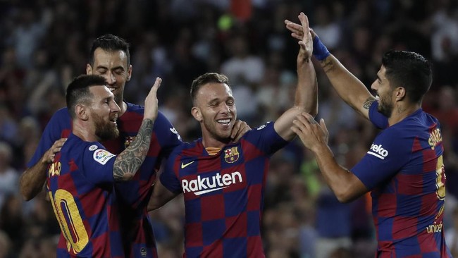 Barcelona's Arthur, centre, celebrates with Lionel Messi, left and Barcelona's Luis Suarez after scoring his side's second goal during the Spanish La Liga soccer match between FC Barcelona and Villarreal CF at the Camp Nou stadium in Barcelona, Spain, Tuesday, Sep. 24, 2019. (AP Photo/Joan Monfort)