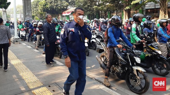 Demo ricuh semalam menyisakan aroma gas air mata pagi ini yang membuat sejumlah pengguna jalan yang melintas di belakang gedung DPR RI melindungi pernafasannya.