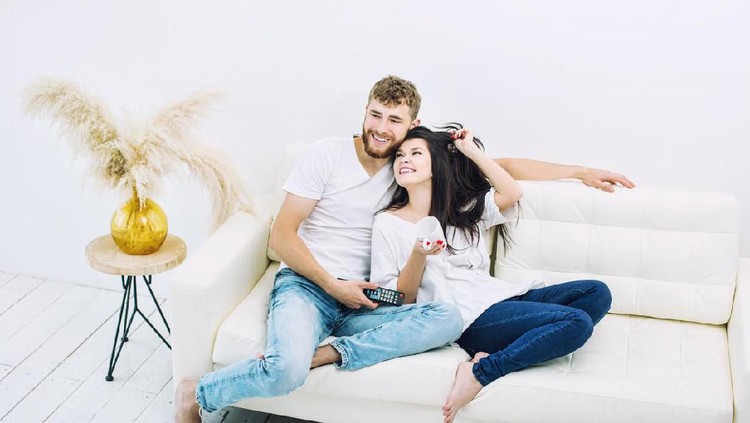Happy affectionate couple enjoying in their love while embracing in bedroom in the morning.