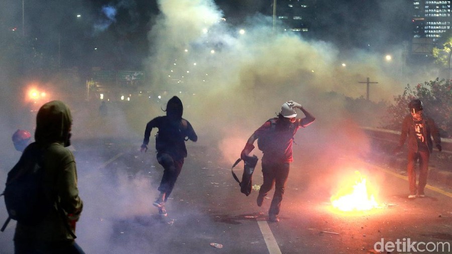 Para pendemo bertahan dari asap dan gas air mata saat berunjukrasa di depan Gedung DPR RI, Jakarta. Inilah potret massa yang berdiri paling depan.