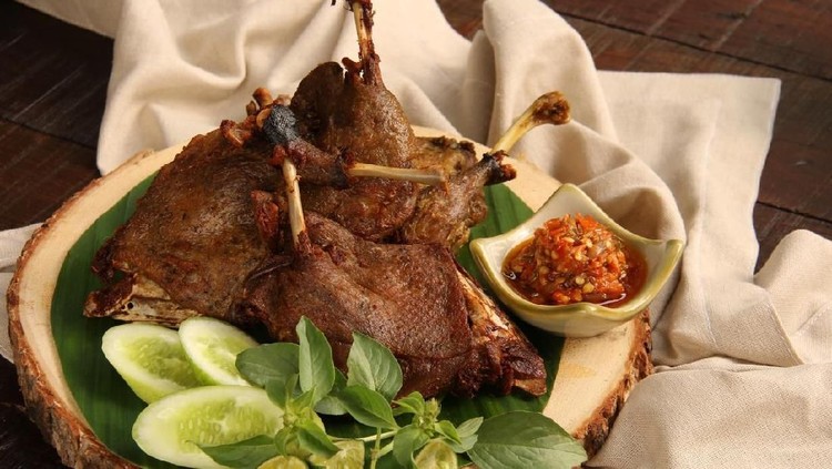 Resep Bebek Goreng Bebek Goreng, one popular Indonesian poultry dish of deep-fried duck; served with fresh vegetables and chili paste. The duck legs are arranged on a natural wooden serving board that has been lined with banana leaf.