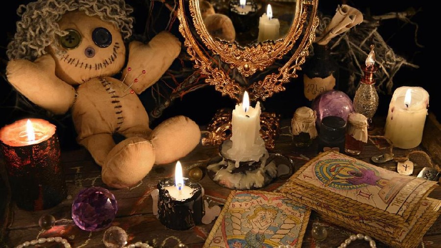 Magic ritual with voodoo doll, mirror, candles and tarot cards. Halloween concept, mystic or divination spell with occult and esoteric symbols. Vintage objects on witch table