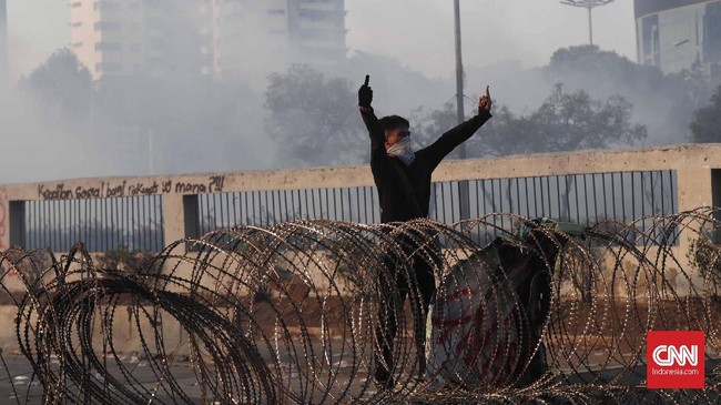 Polisi berupaya menghalangi massa dengan membuat barikade di jalan tol karena demonstran mendekat ke Gerbang DPR.