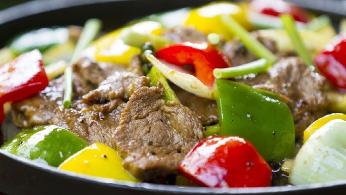 Chinese pepper steak - slices of tender beef stir-fried with red and green bell peppers and onions.