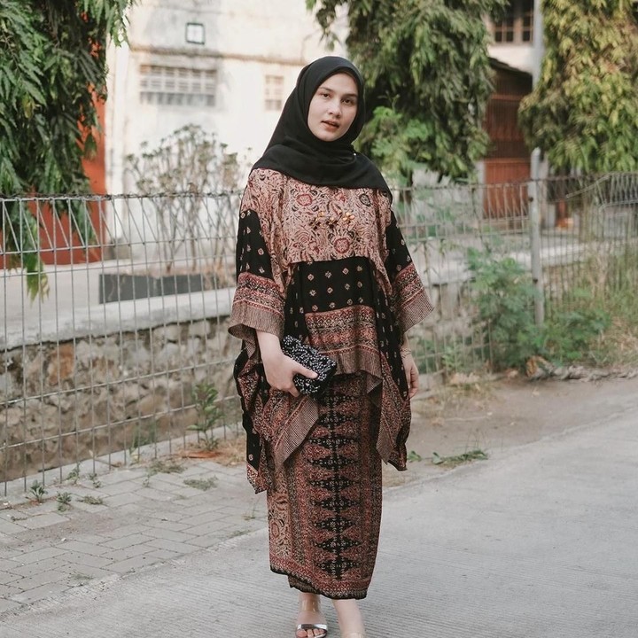<p>Selebgram Dwi Handayani memilih atasan batik cokelat yang dipadu dengan kain berwarna senada. Ia melengkapi tampilannya dengan hijab dan <em>clutch bag</em> berwarna hitam. (Foto: Instagram @dwihandaanda)</p>