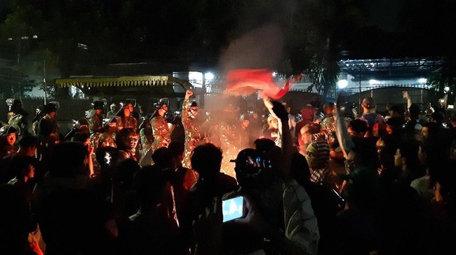 Massa membakar sejumlah benda di jalanan dekat markas FPI, Petamburan, pada Selasa (1/10) dini hari. Personel TNI berdiri tak jauh dari barisan massa.