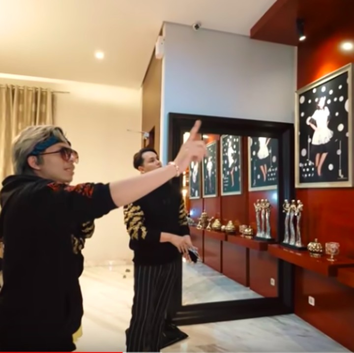 <p>Masih di area ruang tamu, digantung foto seluruh anggota keluarga dalam bingkai berbeda. Di bagian ini mereka memilih warna merah metalik. (Foto: YouTube Atta Halilintar)</p>