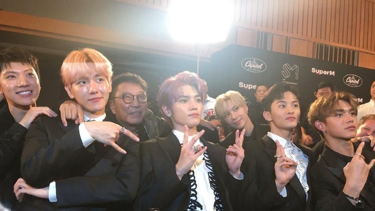 CEO SM Entertainment, Lee Soo Man terlihat merangkul Ten sebagai rasa bangga pada acara pemutaran MV Jopping SuperM, di Los Angeles, California, Jumat (4/10).