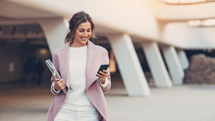 Elegant woman texting outdoors in the city
