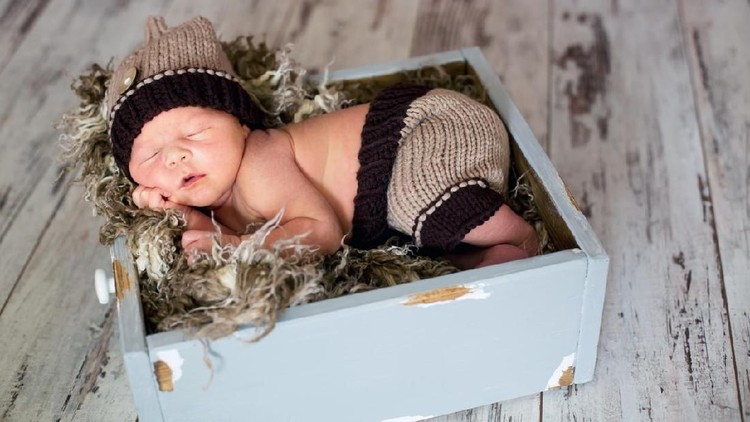 nama bayi Newborn baby boy, sleeping happily in basket